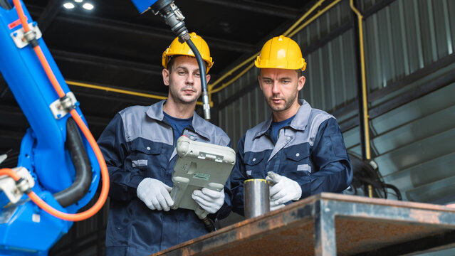 Engineering Professionals reviewing technical information Around an Industrial Robot During Maintenance and Quality Inspection Scene 270