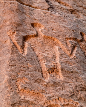 View of an ancient petroglyph carved into sandstone rock in the Wadi Rum Desert, showcasing historic rock art with weathered textures in Wadi Rum Village, Aqaba Governorate, Jordan.