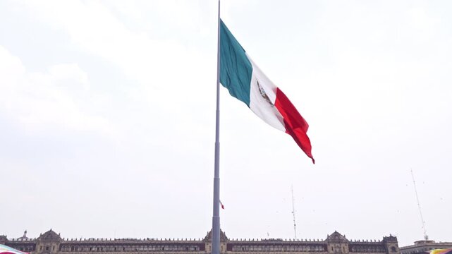 4K video of Mexican flag waving at Zocalo plaza with National Palace background.