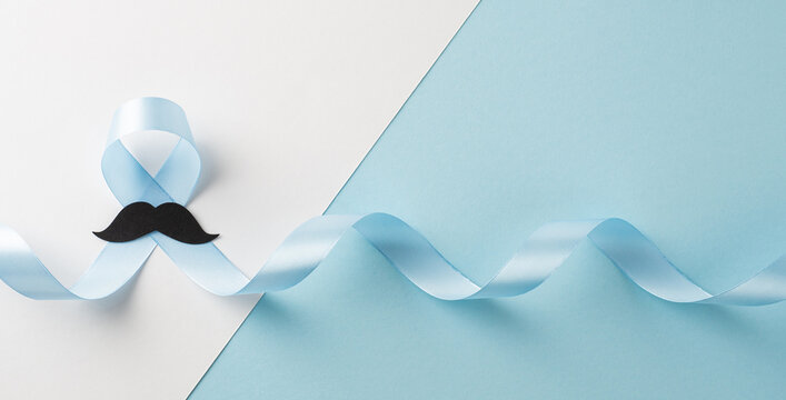 Blue ribbon and mustache symbol for men's health awareness month and prostate prevention campaign on banner blue and white backdrop