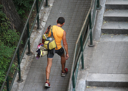 Hombre deportista con mochila subiendo cuesta andando