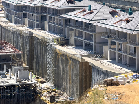 View of modern residential buildings under construction with concrete retaining walls and scaffolding in Avcilar, Istanbul, Turkiye.