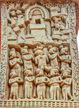Aniconic Buddhist relief depicting the veneration of a sacred empty throne within a chaitya shrine, symbolizing the presence of the Buddha, surrounded by devotees and celestial beings, from Sanchi
