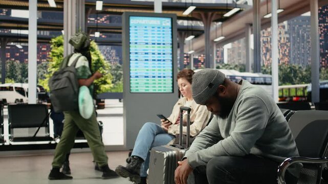 Weary passenger yawns and naps at a bus stop while waiting for the next connection, showing low energy after long waiting times in the coach station.
