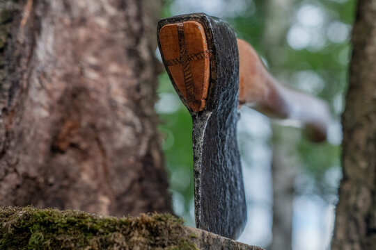 Wood wedge axe assembly closeup with steel head and cross wooden wedge texture view.
