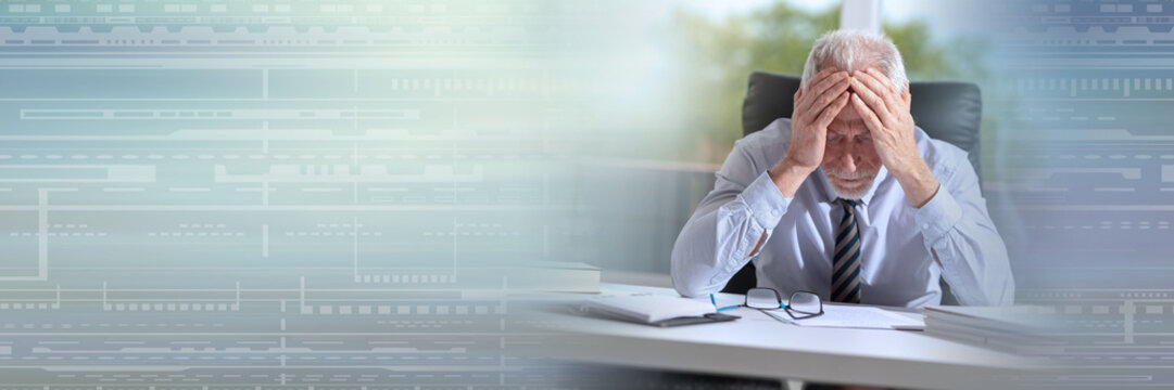 Tired businessman sitting in office; panoramic banner