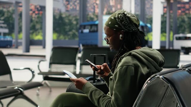 Woman takes a picture of a boarding pass in a bus terminal while searching the route itinerary online, reviewing bus ticket information on her mobile phone before intercity travel.