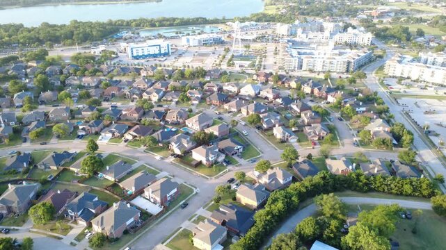 Lush green tree buffers divide Lakewood Estates subdivisions from Lakefront zones. Curving neighborhood avenues, distant lake shorelines portray dynamic regional growth, Little Elm, Texas