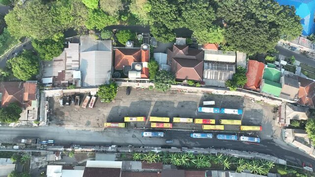 Bogor Timur, Indonesia - 26 July 2026: Aerial view of Baranangsiang bus terminal with parked buses and surrounding urban buildings.