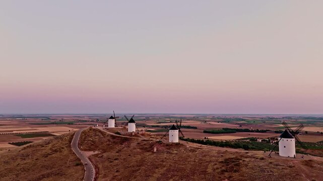 Spanish don quixote windmills on a hill at sunset