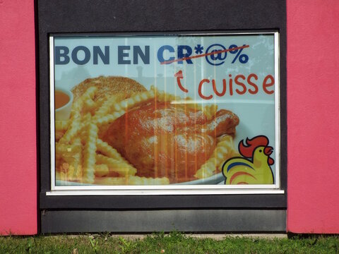 Gatineau, Quebec, Canada &ndash; June 24, 2026: A "restaurant window advertisement" features a delicious roasted chicken leg, french fries, and playful French text with a cartoon rooster on Bd Gr&eacute;ber.