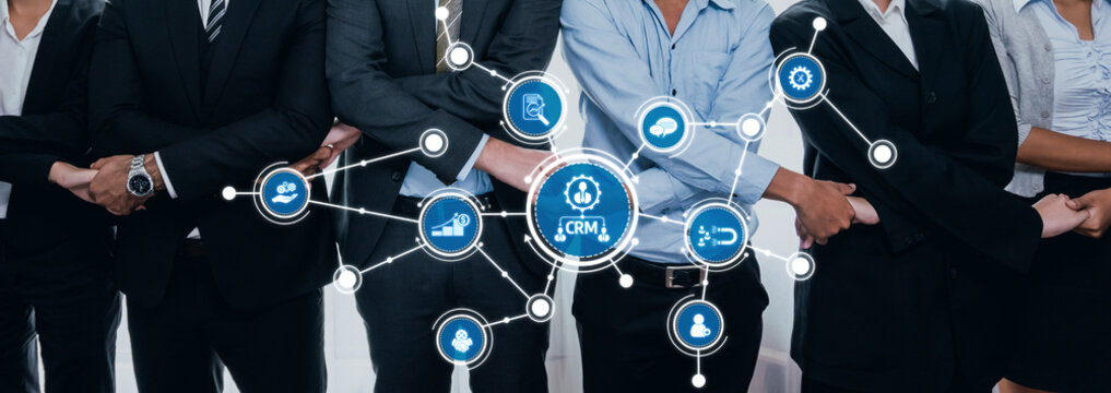 A group of business professionals working together to develop CRM strategies. The modern office setting highlights teamwork and advanced technology integration in business. Amity
