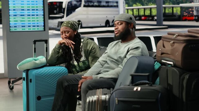 Travel companions discuss future plans beside baggage in bus station