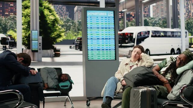 Exhausted travelers sleep on chairs in a bus terminal during a long wait between routes, dozing in the waiting area before continuing their trip.