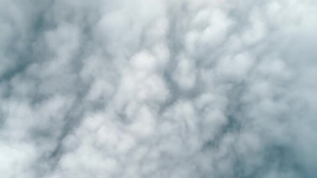 Top-down aerial view of soft white cloud patterns moving slowly like ocean waves in daylight, cinematic 1080p motion background