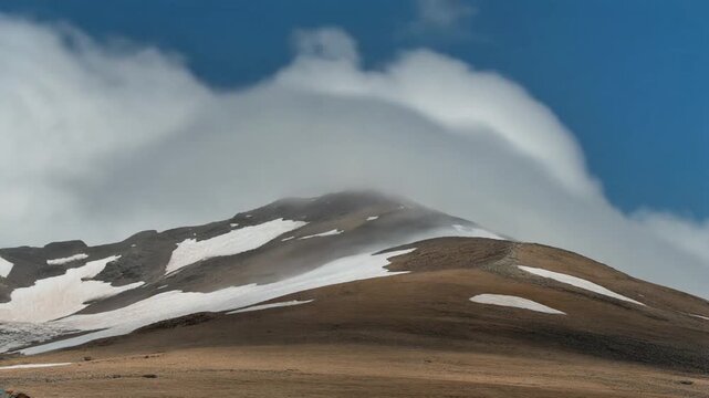 Dramatic Time-Lapse of Fast Moving Clouds Over Barren Mountain Summit with Snow Patches, Full HD Motion Background