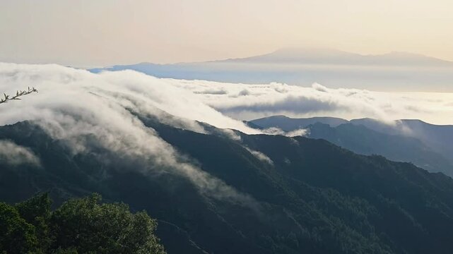 Trade wind sea of clouds flowing over mountains in La Gomera with Teide in the background, Canaries