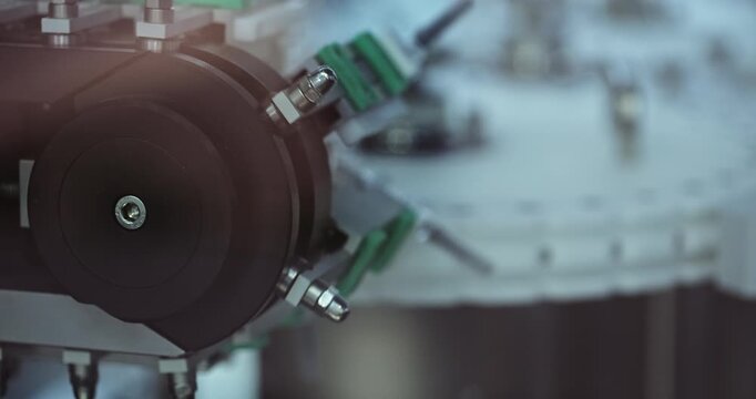 Small glass vials with pharmacy transported by rotating production system at factory. High-capacity manufacturing supports medical packaging operations