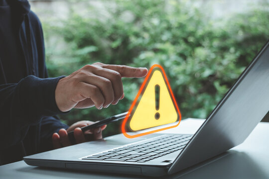 Security warning symbol near a laptop and smartphone, highlighting online risk, cyber threat, data protection, privacy, digital security, and technology awareness in a modern workspace.