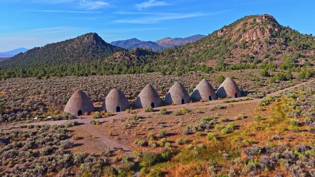 Aerial view of historic stone beehive kilns illuminated by golden sunrise light in Ward Charcoal Ovens State Historic Park Nevada