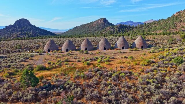 Aerial view of historic stone beehive kilns illuminated by golden sunrise light in Ward Charcoal Ovens State Historic Park Nevada