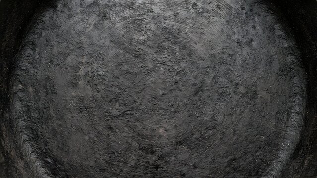 Close-up of a scratched and textured dark gray metal surface, showing wear and tear