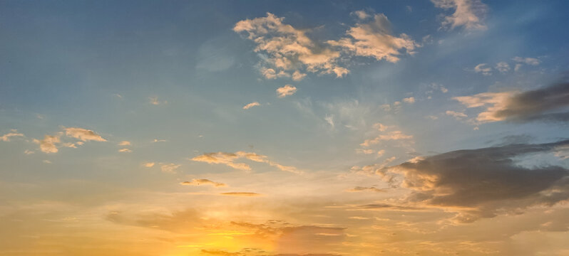 At sunrise or sunset, clouds&mdash;streaked with various hues like orange and reddish-yellow&mdash;lend a dramatic quality to the sky.