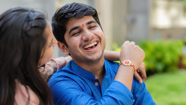 Smiling brother with sister during outdoor rakhi celebration, raksha bandhan sibling celebration, brother sister family bond, indian festive tradition, family togetherness, festive customs