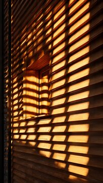 Wooden shutters cast linear shadow patterns across a sunlit window facade.