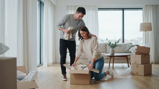 Couple Unpacking Boxes in a New Home, Smiling and Interacting While Moving in Featuring Interior, Relocation