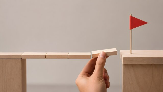 Hand building wooden bridge to reach target flag, symbol of problem solving, risk management, business strategy, overcoming obstacles, and achieving success in career progression