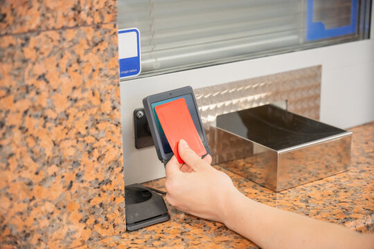 A woman pays for a ride with a bank card at a metro ticket office.
