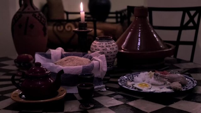 Traditional Moroccan table setting, featuring Terracotta tagine, bread, cakes, and tea, candle burning, cultural dining experience, Moroccan ceramic plates with traditional Moroccan patterns