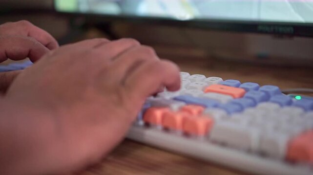 Fingers typing fast on RGB mechanical keyboard, close-up shot. Gaming setup, computer technology, workspace stock video footage clip.