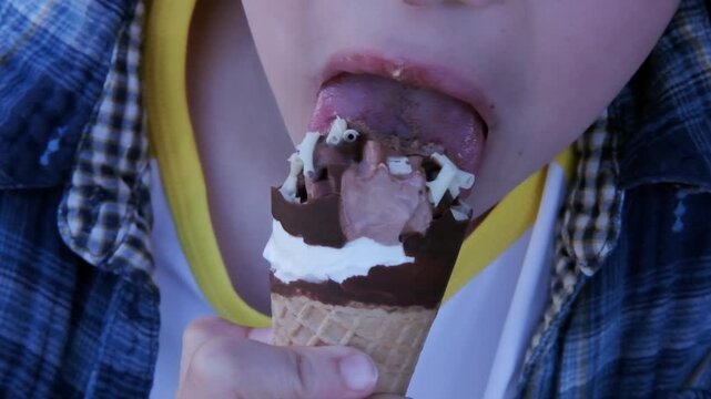 close-up of part child's face, boy 10-11 years old Asian-European appearance eating chocolate ice cream, concept of good appetite, happy childhood, balanced diet, sweet life, unhealthy food