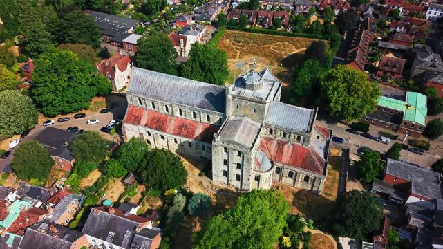 Drone shot showing the entire footprint of Romsey Abbey, its cross-shaped roof, apse and surrounding streets.