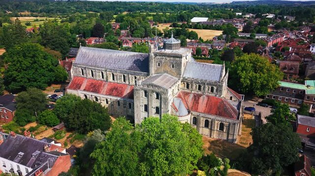 Drone shot showing Romsey Abbey's full cross-shaped roofline, transept, tower and rounded apse from above.