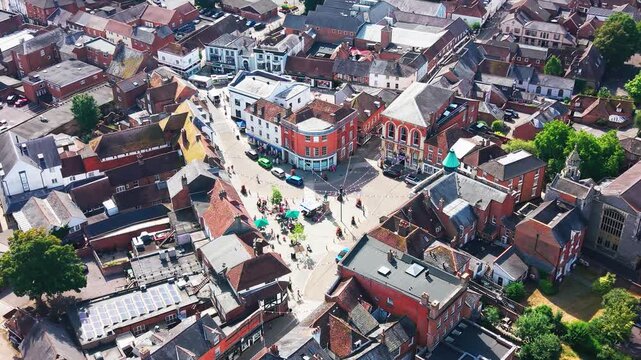 Drone shot over Romsey's historic market square, high street shops and town hall, with the Abbey nearby.