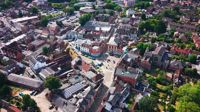 Drone flyover of Romsey's market square and high street, moving past shops, the town hall and church.