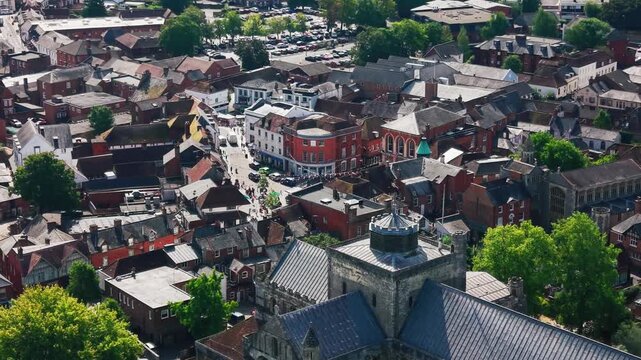 Drone shot over Romsey's market place, high street and the Abbey's crenellated tower in the foreground.