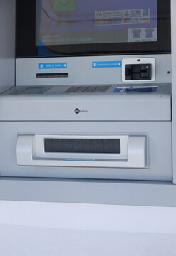 202608-24 Lisboa, Portugal - Multibanco ATM embedded in a white wall, featuring the ATM and MB Multibanco branding. The machine includes a screen, card reader, keypad, cash dispenser, and contactless 