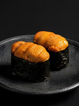 Two pieces of uni gunkan maki (sea urchin battleship sushi).