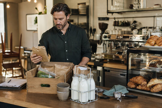 Cafe Owner Checking Fresh Ingredient Delivery Before Opening