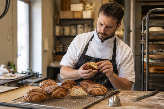 Baker Inspecting Fresh Pastry Quality During Morning Bakery Production
