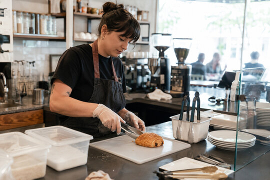 Cafe Worker Preparing Pastry with Separate Utensils for Food Safety