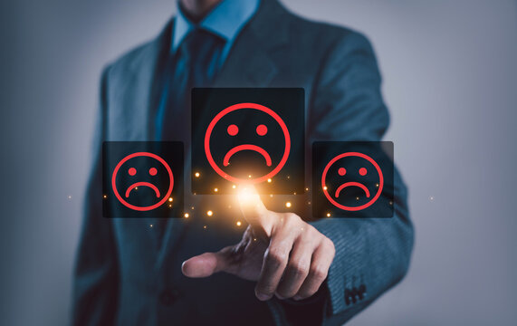 Business professional interacting with digital sad face icons, symbolizing customer dissatisfaction negative feedback poor service experience complaint management brand reputation and customer service