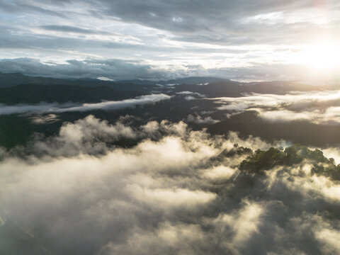 Misty mountain landscape, cloud layer, sunrise, forest, aerial view, dramatic sky