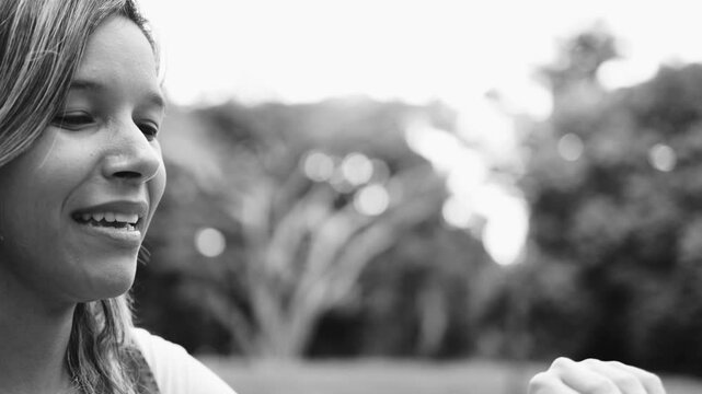 Happy woman blowing soap bubbles outdoors - Black and white editing