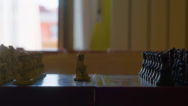 Chess player hand moving piece close up during a tactical board game competition. Strategic mind game match, finger holding a carved pawn on a vintage board, indoor static shot.
