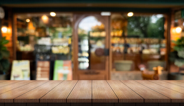 Empty wooden table top with lights bokeh on blur restaurant background.